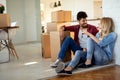 Young couple Moving in new home and unpacking carboard boxes