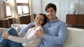 Young married couple renters resting together on comfortable sofa.