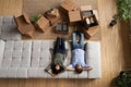 Young married couple rest on cozy couch after packing stuff Royalty Free Stock Photo