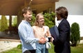 Young married couple shaking hands with realtor, making deal about house purchase outside Royalty Free Stock Photo