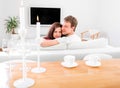 Young married couple sitting on the couch and watching tv at home, rare view Royalty Free Stock Photo