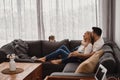 Couple sitting at sofa and looking at their small cat. Relax at home Royalty Free Stock Photo