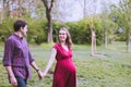 Young married couple taking a walk in the park, they are expecting a baby soon Royalty Free Stock Photo