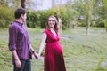 Young married couple taking a walk in the park, they are expecting a baby soon Royalty Free Stock Photo
