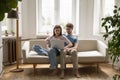 Young married couple using laptop at home, resting on couch Royalty Free Stock Photo