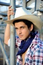 Young masculine and handsome cowboy poses by the bleachers after riding in the rodeo.