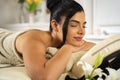Young masseuse massaging pretty dark hair woman in spa salon