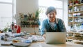 A young master conducts training online using a laptop in the studio. Man in an apron talking by video call Royalty Free Stock Photo