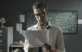 Young mathematician studying in his office and reading papers