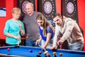 Young and mature couple playing billiard