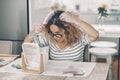 Young mature lady at home having care of her long hair looking for white or grey ones at the mirror sitting on the table. Royalty Free Stock Photo