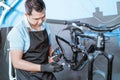 a young mechanic wears gloves holding the bottom bracket to lubricate with oil