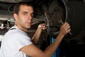 Young Mechanic working below car