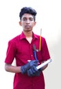 Young mechanic writing on a clipboard on a white and gray background