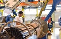 young mechanical engineering workers operate a machine for winding copper wire - manufacture of transformers in a factory Royalty Free Stock Photo