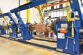 young mechanical engineering workers operate a machine for winding copper wire - manufacture of transformers in a factory