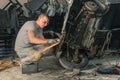 Young mechanical worker repairing an old vintage car