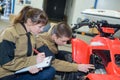 Young mechanics examining quadbike