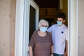 Young medic helping and old eldery woman to walk wear mask covid19 Royalty Free Stock Photo