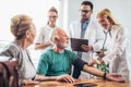 Young medic taking blood pressure during home visit Royalty Free Stock Photo