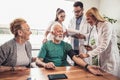 Young medic taking blood pressure during home visit Royalty Free Stock Photo