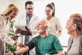 Young medic taking blood pressure during home visit Royalty Free Stock Photo