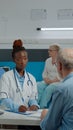 Young medical assistant giving x ray to doctor sitting at desk Royalty Free Stock Photo