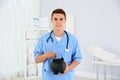 Young medical assistant putting money into piggy bank Royalty Free Stock Photo