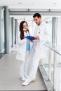 Young Medical Colleagues Analysing Data On Paperboard