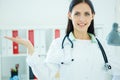 Young female medical doctor presenting and showing copy space for product or text. Royalty Free Stock Photo