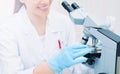 young medical researcher looking through microscope in laboratory