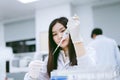 Young female scientist using auto pipette to transfer sample