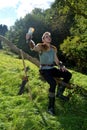 Young Medieval dressed man, holds drinking horn high in the hand, looks upwards