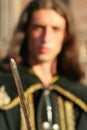 Young medieval prince with saber and black mantle