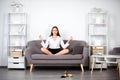 Young meditation businesswoman, secretary girl doing yoga exercise on sofa at workplace in a modern office. Employee