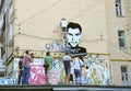 Young men activists set the poster portrait of famous Ukrainian poet and dissident Vasyl Stus on the wall of the