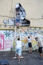 Young men activists set the poster portrait of famous Ukrainian poet and dissident Vasyl Stus on the wall of the