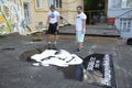 Young men activists set the poster portrait of famous Ukrainian poet and dissident Vasyl Stus on the wall of the