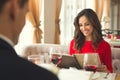 Young couple having romantic dinner in the restaurant holding menu choosing Royalty Free Stock Photo