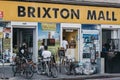 Young men on bikes relaxing outside Brixton Mall. Brixton, South London, UK