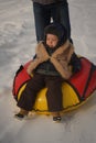 Young man with cheerful boy with roller coaster ride in winter on the ice. Handsome dad and son laughing in a winter Royalty Free Stock Photo