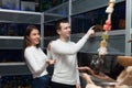 Man with girlfriend selecting tropical fish in aquarium tank Royalty Free Stock Photo