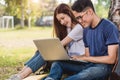 Young man and girls friend classmates sitting under tree consult Royalty Free Stock Photo