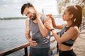 Young man has a pain in the neck. He has put a hand on the place where the pain is. His girlfriend has put her hands on Royalty Free Stock Photo