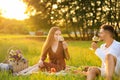 Young man and his girlfriend having picnic in park