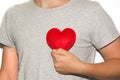 Young men hold red heart in hand.