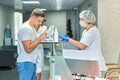 Young man in hospital at the reception fills out documents with doctor