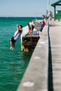 Young men jumping off jetty into water Royalty Free Stock Photo