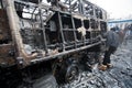 Young men look at the burned out military auto on the barricades of occupying snow city during riot