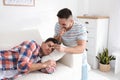 Young man with marker near sleeping friend. April fool`s day Royalty Free Stock Photo